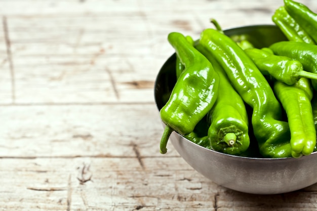 Pimientos crudos verdes frescos en un recipiente de metal