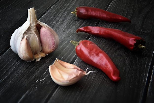 Pimientos picantes con ajo en la mesa de madera negra