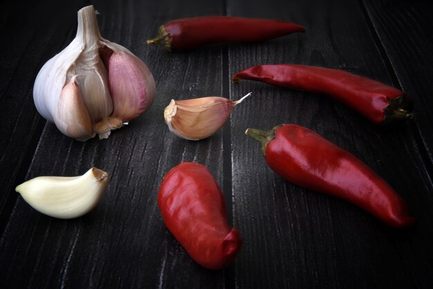 Pimientos picantes con ajo en la mesa de madera negra