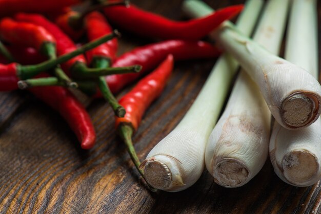 Pimientos picantes mexicanos con hierba de limón esparcidos sobre la mesa de madera