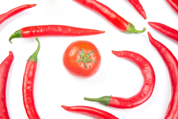 Pimientos picantes y tomate sobre blanco