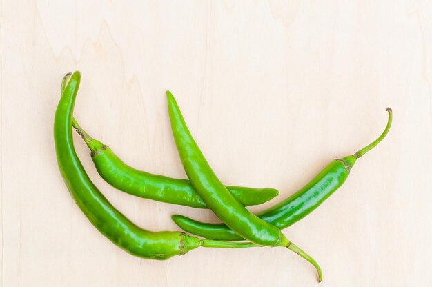 Pimientos picantes verdes frescos con picante en la madera