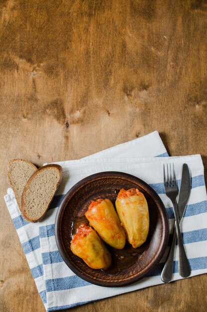 Pimientos rellenos con arroz y carne picada guisada en tomates, pan de centeno. La comida rústica.