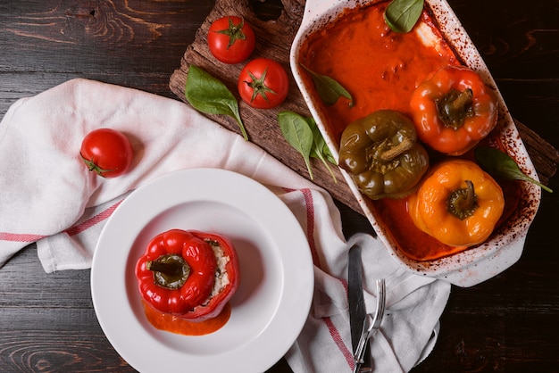 Pimientos rellenos caseros. con relleno de albahaca, espinacas, queso y especias. con salsa de tomates frescos caseros. Hecho en un estilo rústico.