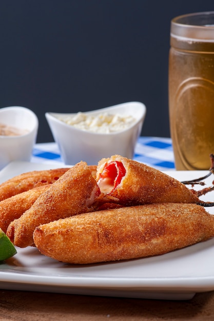 Pimientos rellenos de queso, empanizados y fritos. Acompañado de cuajada, salsa de rosas y limón.