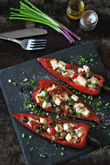 Pimientos rellenos de queso feta y aceitunas. Pimentón al horno con aceitunas y queso blanco. Comida vegetariana. Dieta Keto.