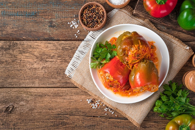 Pimientos rellenos rojos y verdes sobre un fondo de madera