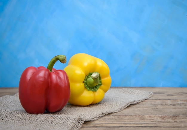 Pimientos rojos y amarillos sobre un fondo azul.