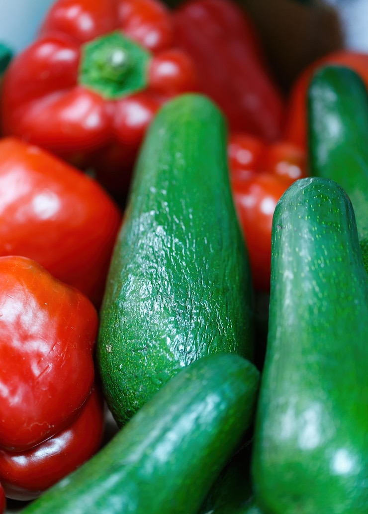 Foto pimientos rojos frescos y aguacates el enfoque está en los aguacates en primer plano con los pimientos rojos ligeramente desenfocados en el fondo relevante para temas relacionados con la alimentación saludable
