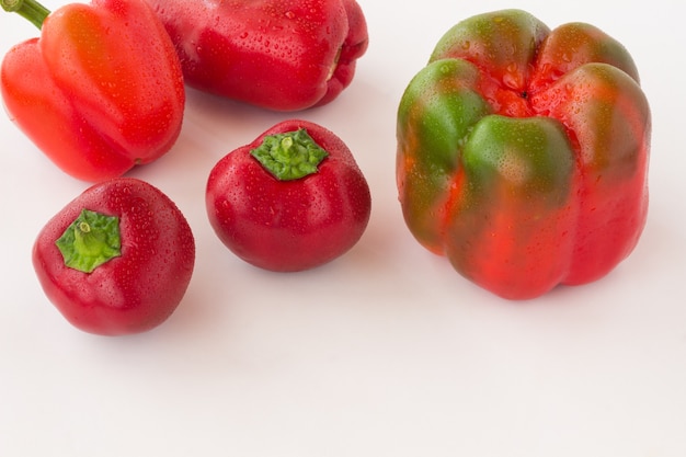 Pimientos rojos con gotas de agua sobre un espacio en blanco