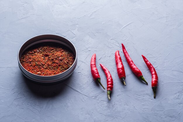 Pimientos rojos y hojuelas de chile sobre fondo gris