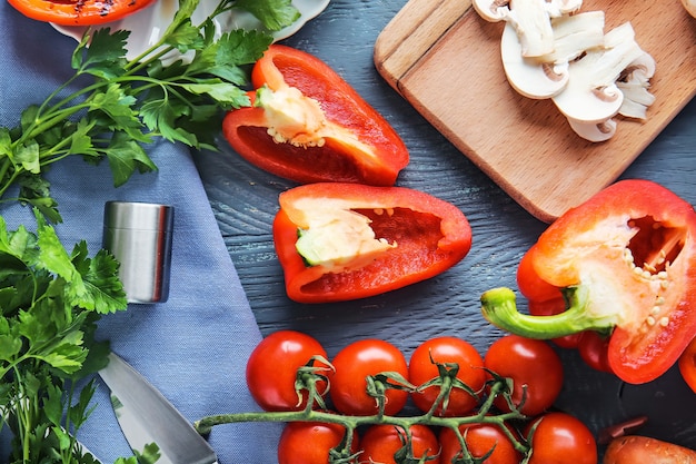 Pimientos rojos maduros con otras verduras en la mesa