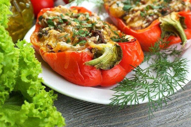 Pimientos rojos rellenos con verduras y verduras en la mesa de cerca