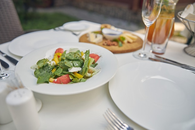 pimientos y tomate con ensalada verde de pie en la mesa del comedor