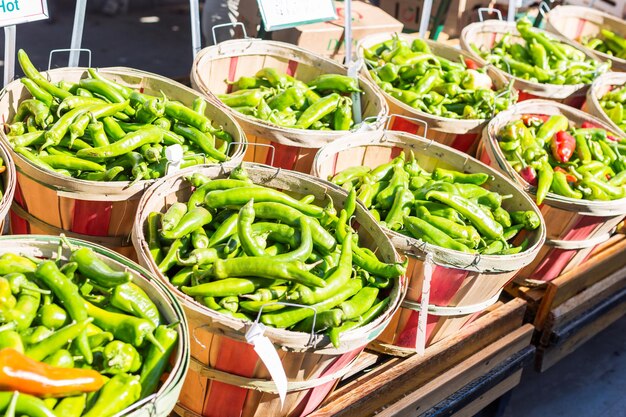 Pimientos verdes en cestas en el mercado de agricultores local.