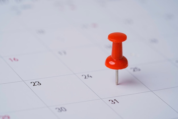 Pin rojo en el calendario para reuniones de negocios y concepto de planificación de viajes