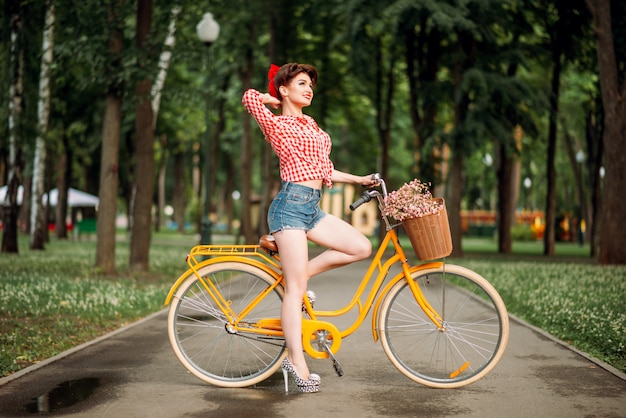 Pin-up girl en bicicleta, moda americana vintage