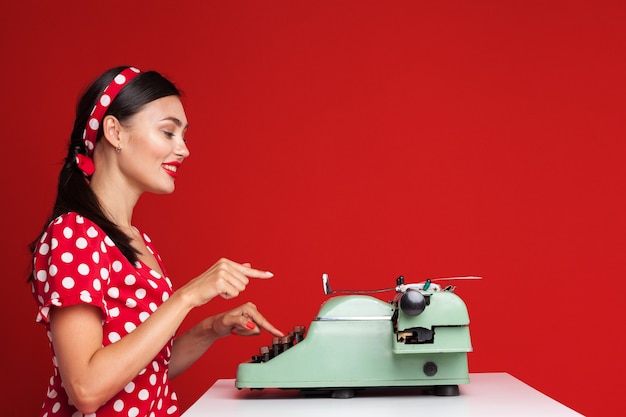 Pin up girl escribiendo en una máquina de escribir