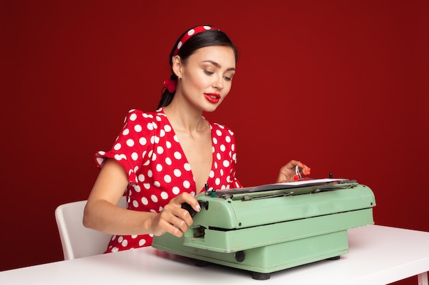 Pin up girl escribiendo en una máquina de escribir