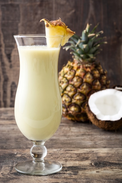 Piña colada cocktail em vidro em madeira.