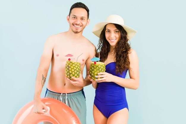 Pina-Colada-Cocktails am Strand. Porträt eines gutaussehenden Paares auf ihrer Hochzeitsreise, das einen Drink in seinem tropischen Urlaub genießt