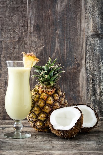 Piña colada cóctel en vidrio sobre madera.