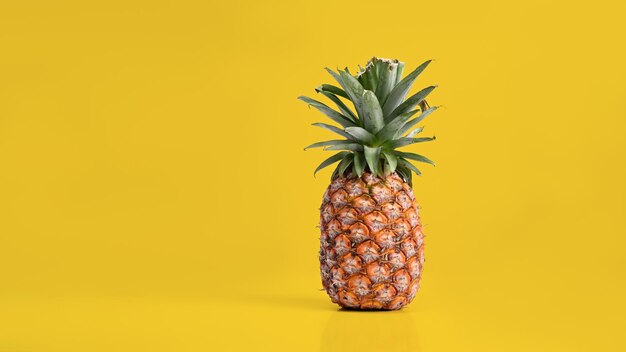 Piña entera sobre fondo amarillo con espacio de copia Concepto de frutas tropicales de verano