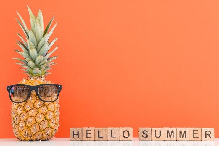 Piña fresca con gafas de sol sobre fondo de color Hola verano