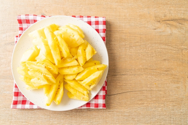 Piña fresca en rodajas en un plato blanco.