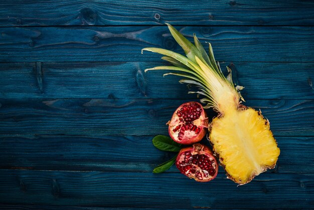 Piña y granada Frutas frescas Sobre un fondo de madera Vista superior Espacio libre para texto