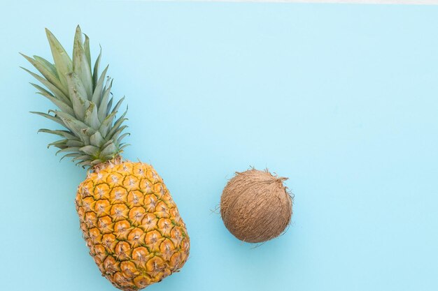 Piña madura y coco sobre un fondo azul Hola concepto de verano