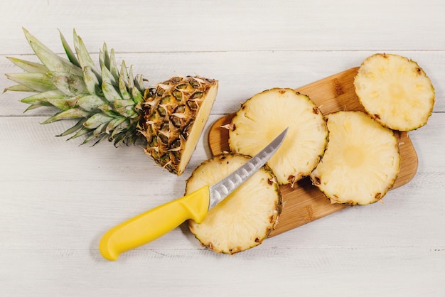 Piña madura cortada en rodajas sobre fondo de madera