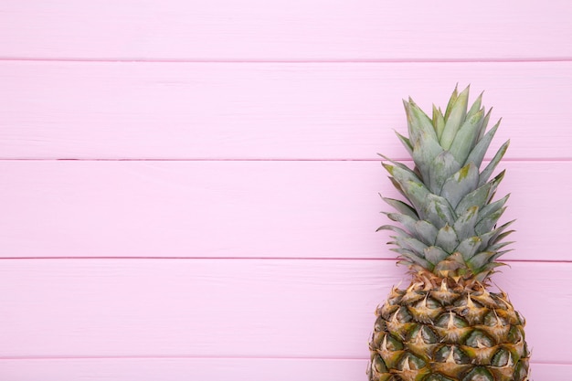 Foto piña madura sobre un fondo rosa con espacio de copia