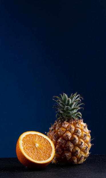 Piña y naranja sobre un fondo azul.