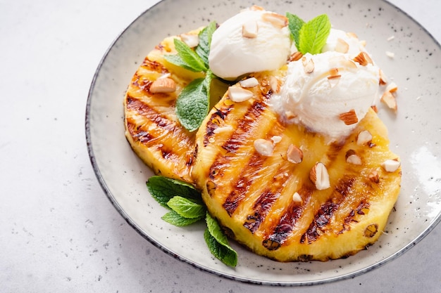 Piña a la parrilla con bolas de helado de vainilla sobre una piña