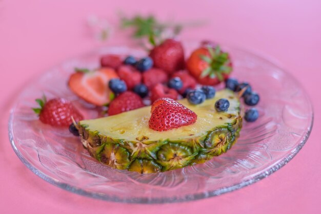 Foto una piña en un plato con bayas y fresas.