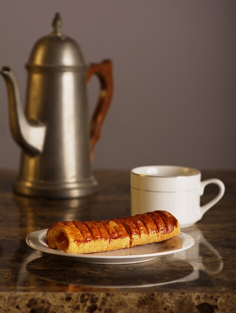 Piña rellena de pan con una tetera una taza de té.