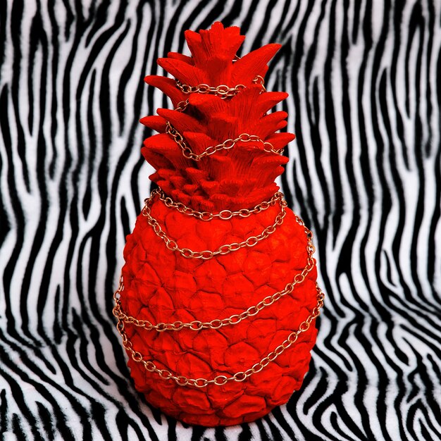 Piña roja sobre fondo de estampado de cebra. Arte creativo mínimo