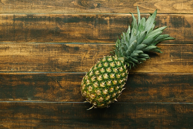 Piña verde en una mesa de madera rústica