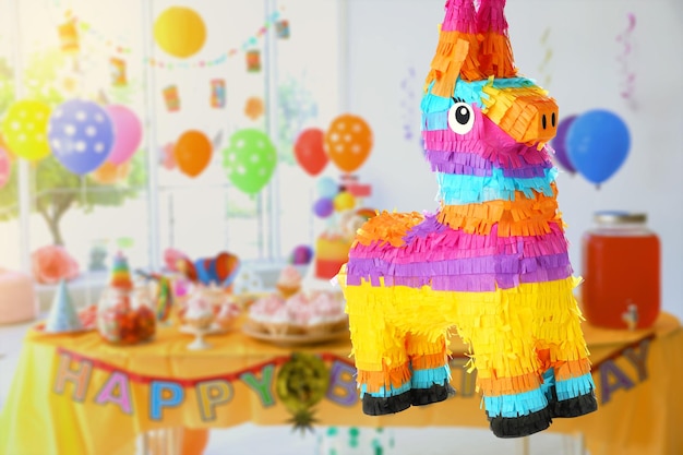 Foto piñata festiva brillante colgando en el interior en el espacio de la fiesta de cumpleaños para texto