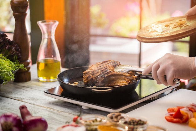 Pinças segurando a mão de carne frita em luva branca Porco assado suculento é uma verdadeira iguaria