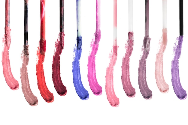 Foto pincéis de batom líquido coloridos e amostras de cores em fundo branco