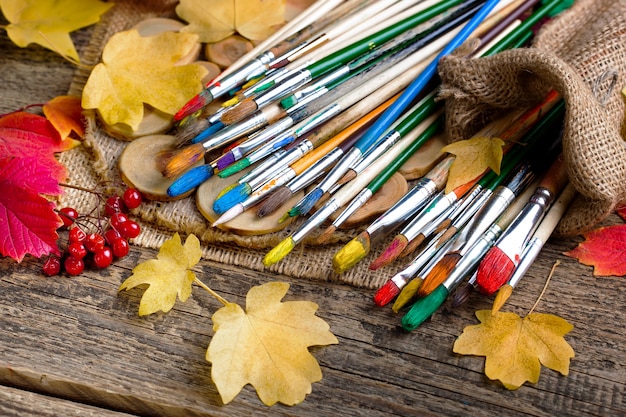 Pincéis e tintas para desenhar na composição em cima da mesa.