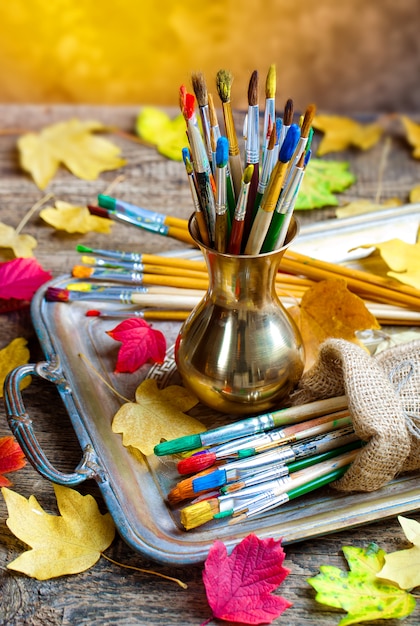 Foto pincéis e tintas para desenhar na composição em cima da mesa.