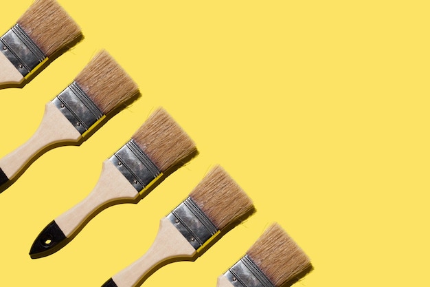 pincéis para pintar e reparar em um fundo amarelo