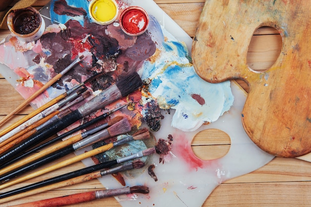 Pincel artístico y tintas de colores en latas