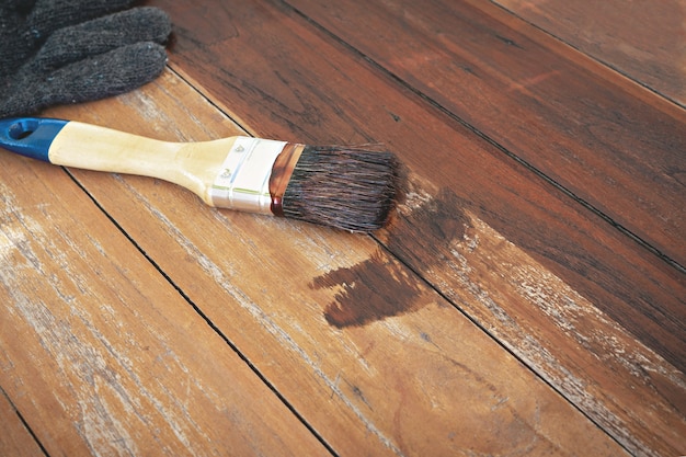 Pincel y guantes puestos en la mesa de madera.