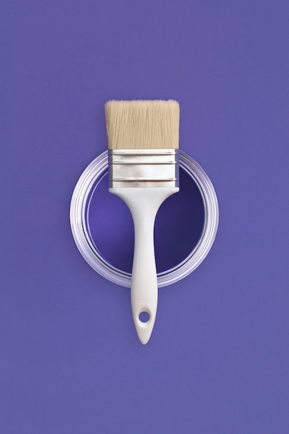 Pincel de pintura con una lata abierta de pintura en el color de fondo muy trendy del año 2022