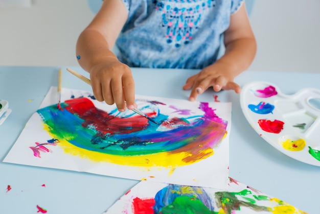 Pincel con pintura en la mano del niño.