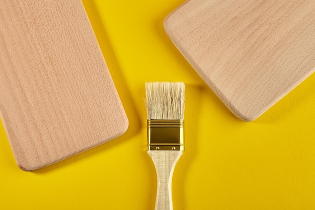 Foto pincel y productos de madera sobre un fondo amarillo vista desde arriba flat lay